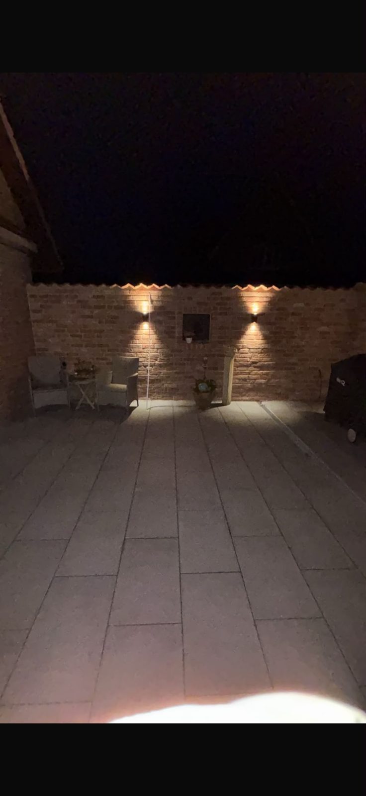 Außenanlage / Grillplatz – Ergebnis: gepflasterter Sitz- und Grillbereich bei Abendlicht