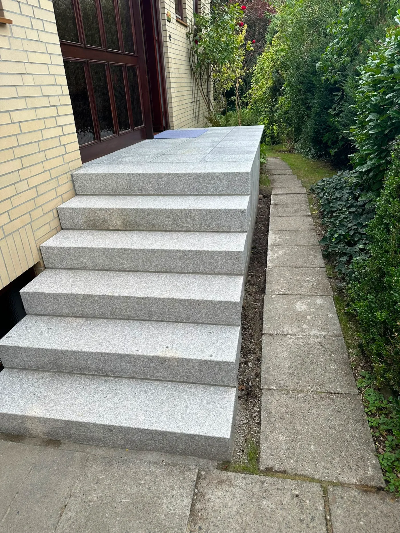 Treppeneingang – Nachher: Seitenansicht der fertigen Granittreppe mit massiver Granit-Wange